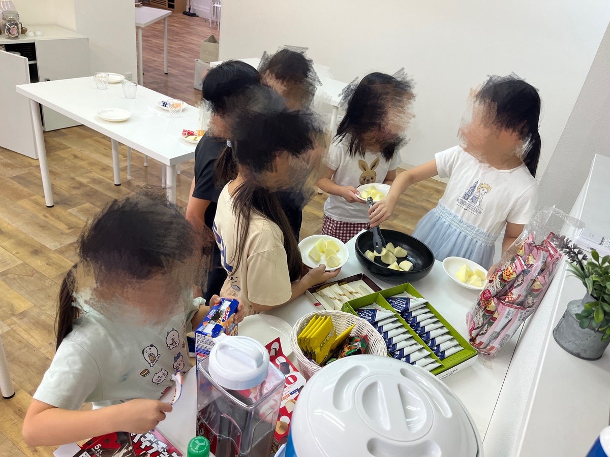 キッチンでおやつを取り分けるこどもたち
