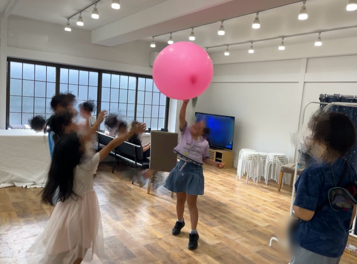 大きなピンクのボールで遊ぶこどもたち