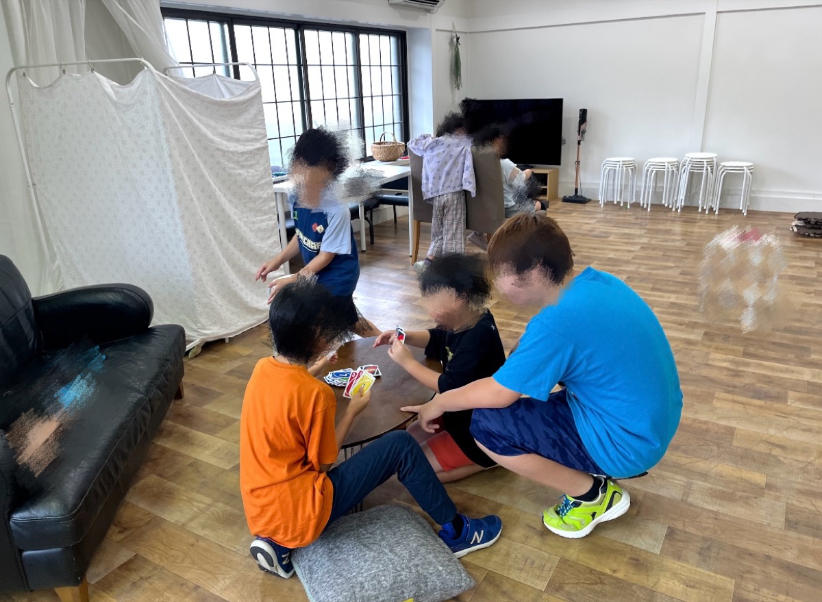 室内でカードゲームを楽しむこどもたち