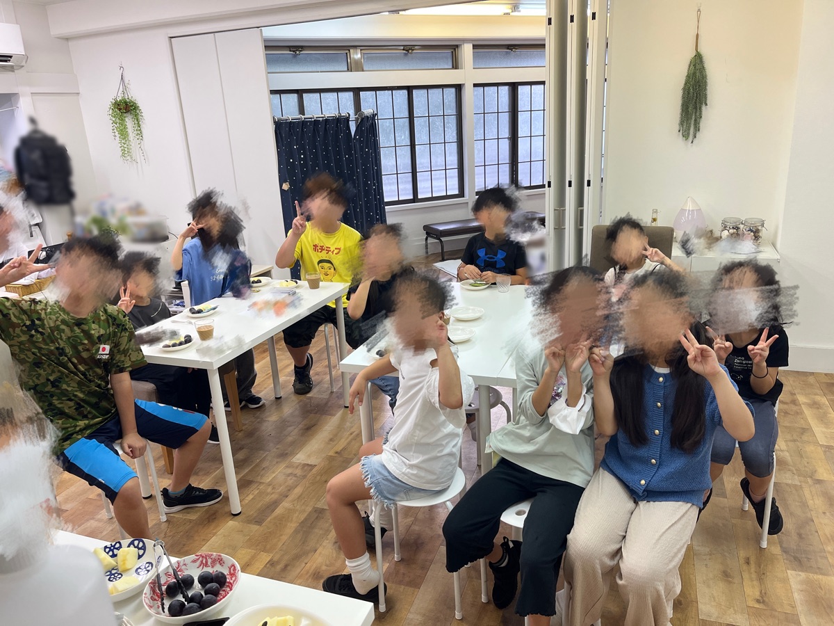 おやつの時間にテーブルを囲むこどもたち