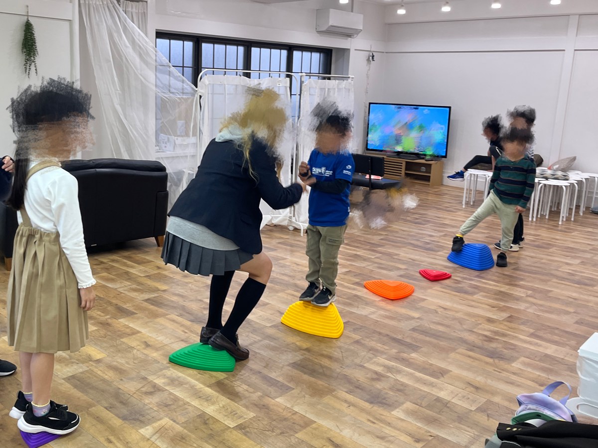 室内でカラフルなバランス遊具を楽しむこどもたち