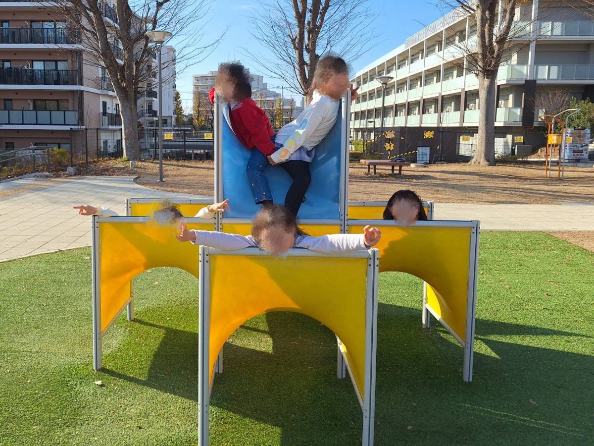 公園の黄色と青の遊具で遊ぶこどもたち