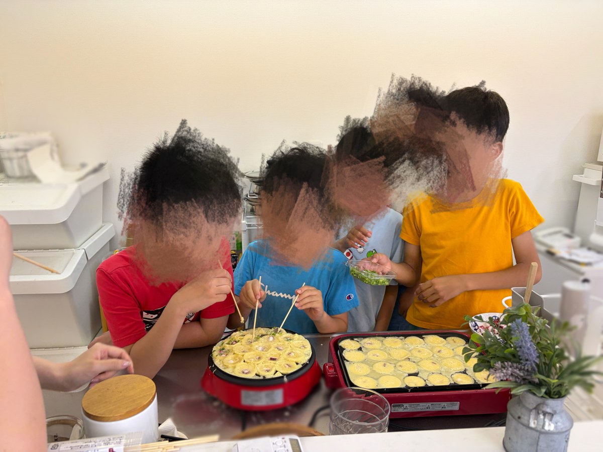 キッチンでたこ焼きを作るこどもたち