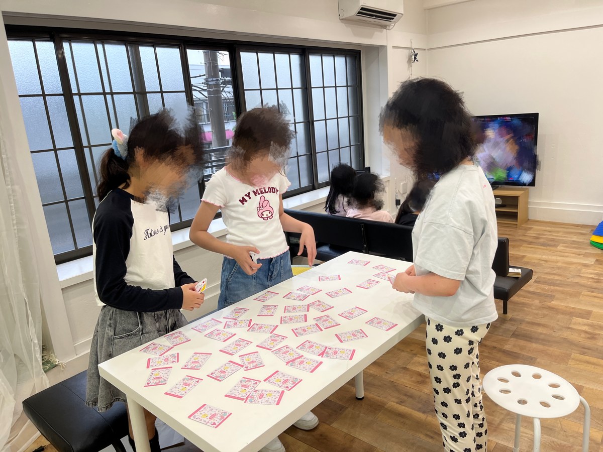 テーブルにカードを並べて遊ぶこどもたち
